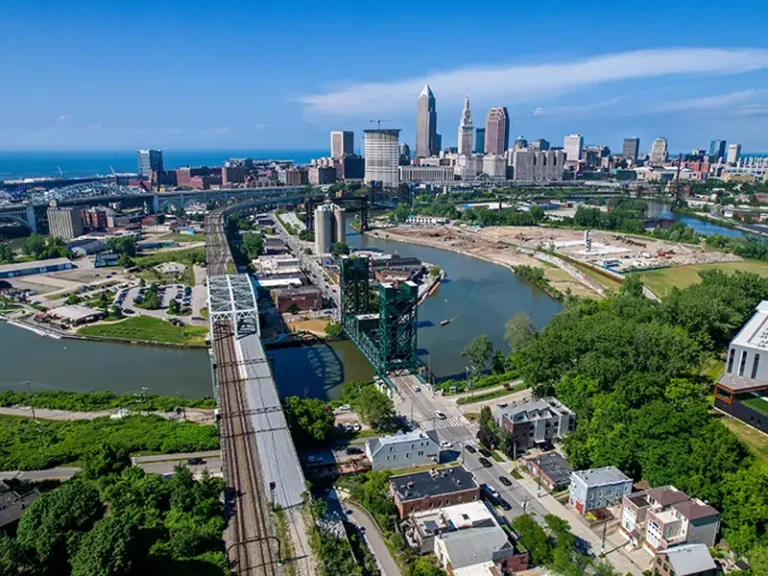 Aerial view of a city skyline with bridges over a river and surrounding buildings.